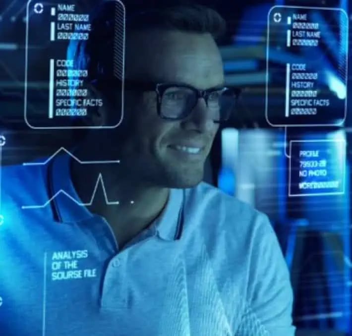 Ein Mann mit Brille schaut auf transparente digitale Bildschirme, auf denen Daten, Diagramme und Profile in einer High-Tech-Umgebung angezeigt werden.